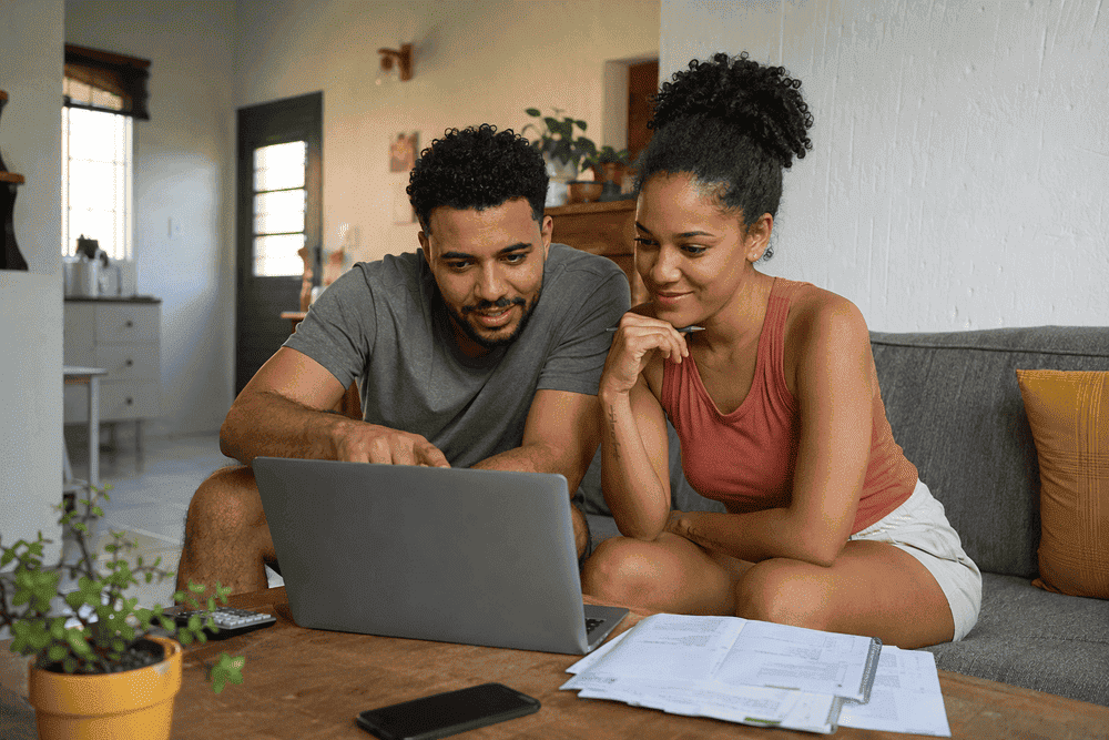 Casal renegociando dívidas pelo computador em casa
